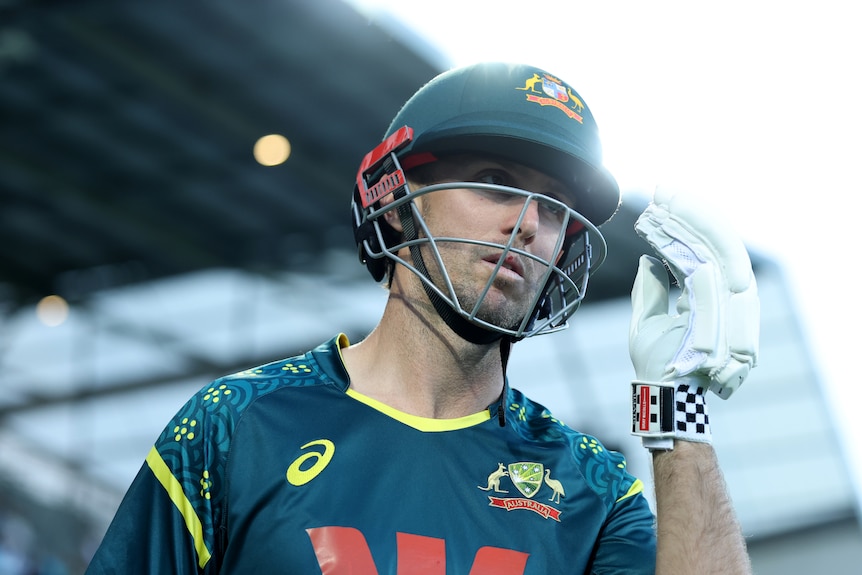 Mitchell Marsh wearing a helmet and left arm up