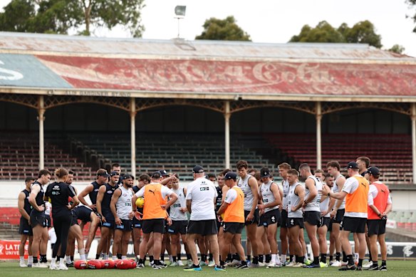 Coach Michael Voss (centre) addresses his players at a pre-season training hit.