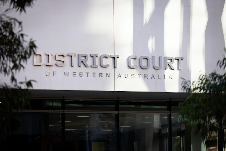 A close-up shot of the District Court of WA in Perth, showing signage on the building's front facade with the court's name.