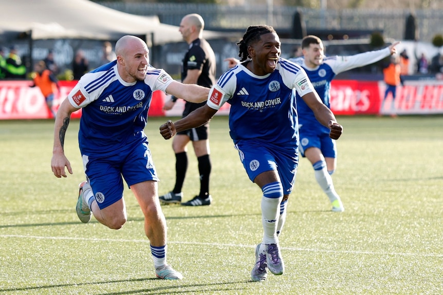 Several football players running and celebrating