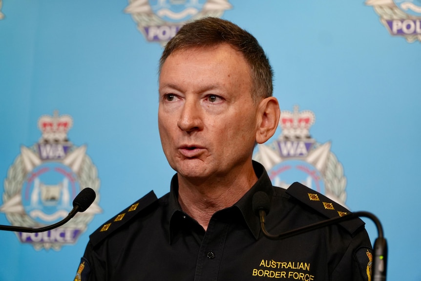 A head and shoulders shot of Australian Border Force Inspector David Williamson speaking at a media conference indoors.