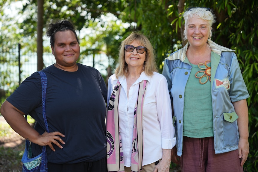 Three women smiling at the camera.