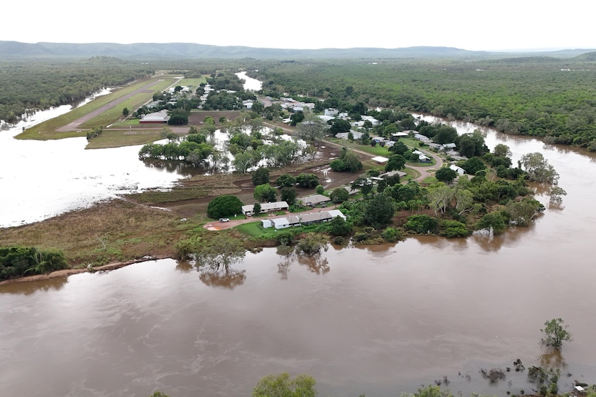 A swollen river surrounds a group of houses