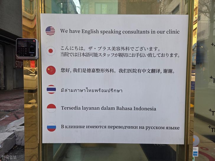 A notice at the entrance of a plastic surgery clinic in Seoul’s Gangnam District informs visitors in six languages that staff who speak those languages are available. Korea Times photo by Son Young-ha