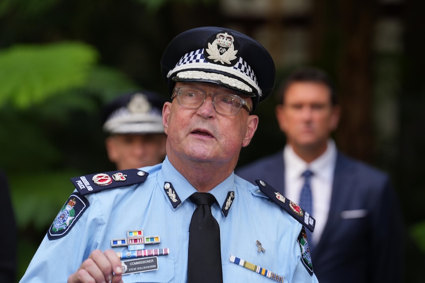 A police officer in formal uniform speaking at a presser