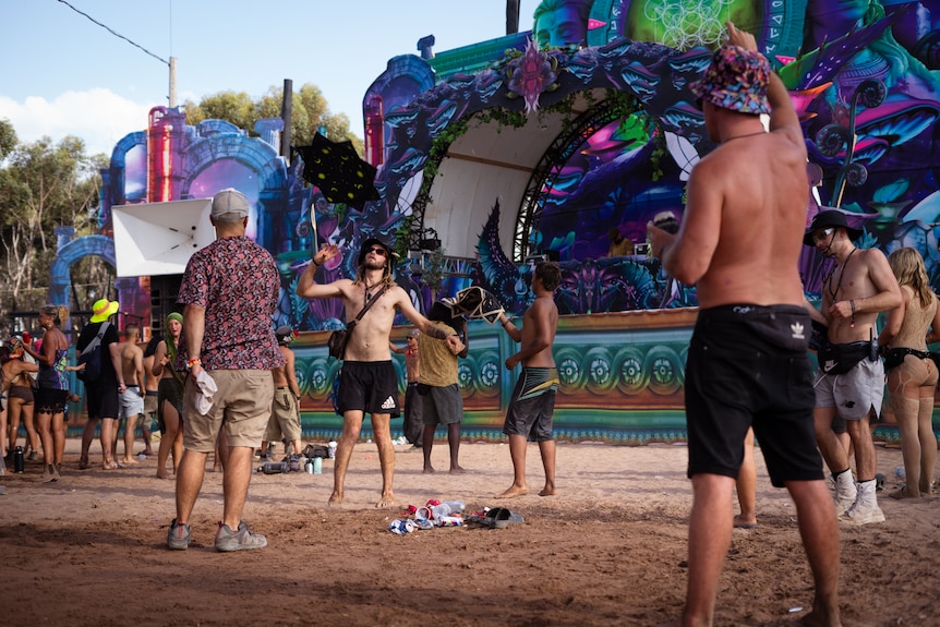 dancers on a dusty dancefloor with a small pile of rubbish at their feet