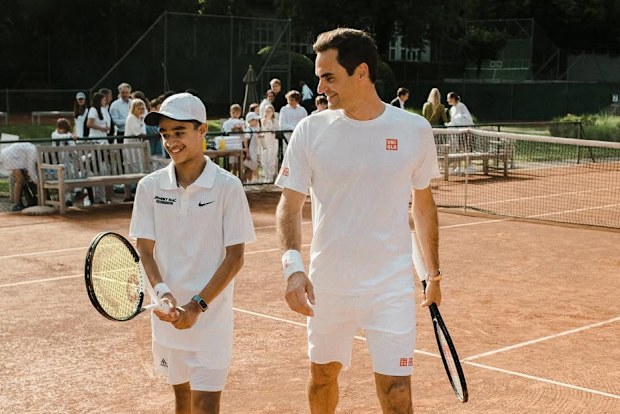 Izyan 'Zizou' Ahmad poses with Roger Federer on the court.