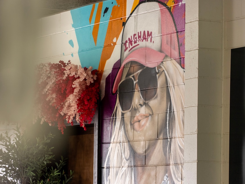 A large mural of the artist Towns And I wearing a hat that says 'Tones and Ingham'