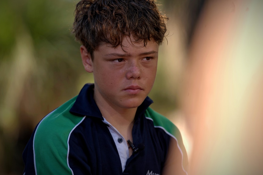 A boy poses for a photo in an outdoor setting
