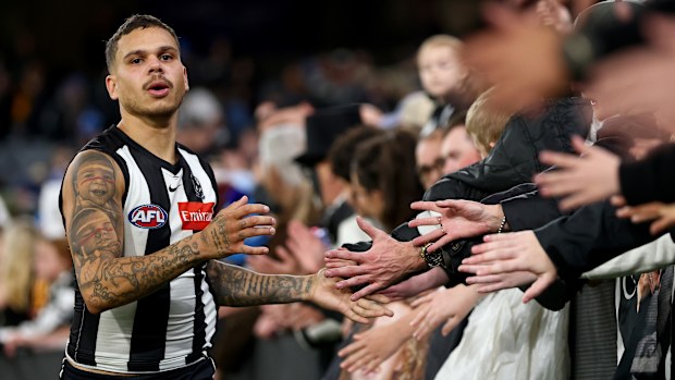 Bobby Hill of the Magpies high-fives fans.