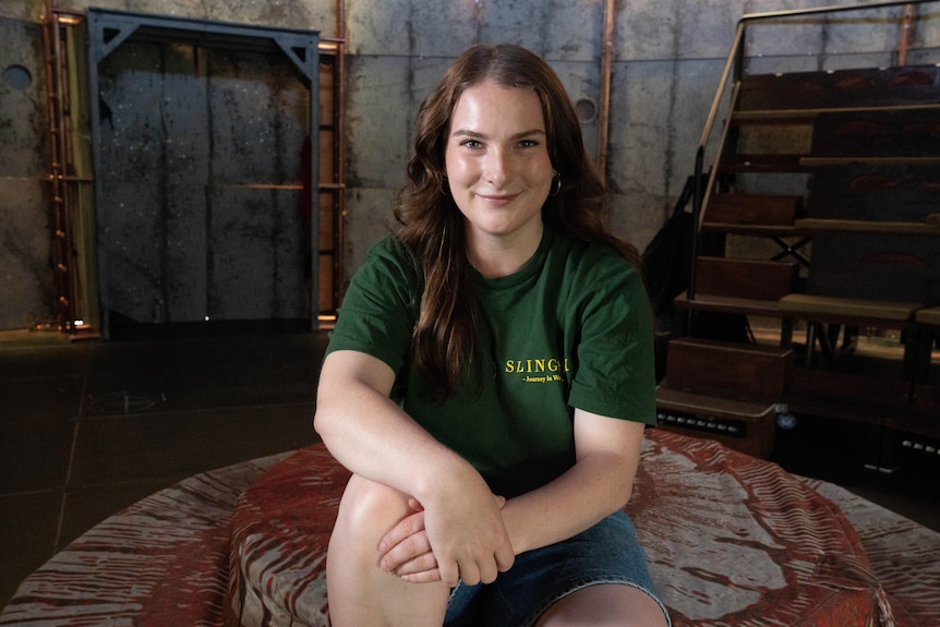 Actor Ren Williams sits on stage