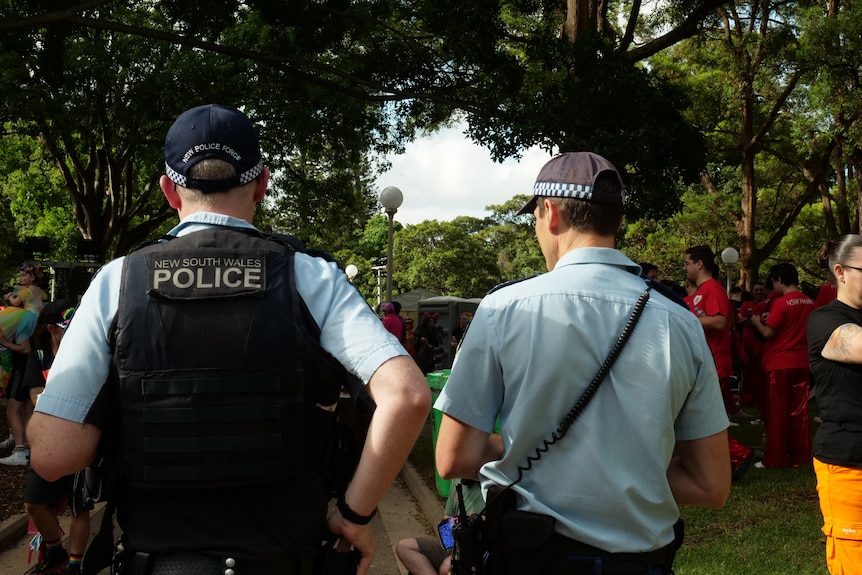 Two police officers mingle with mardi gras attendees.