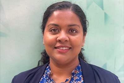 A headshot of a smiling Sri Lankan woman.