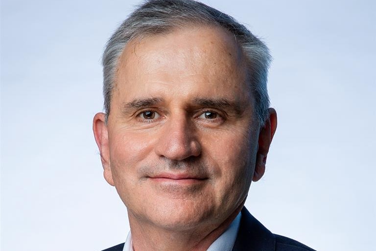 Academic in a suit posing for a professional photograph.