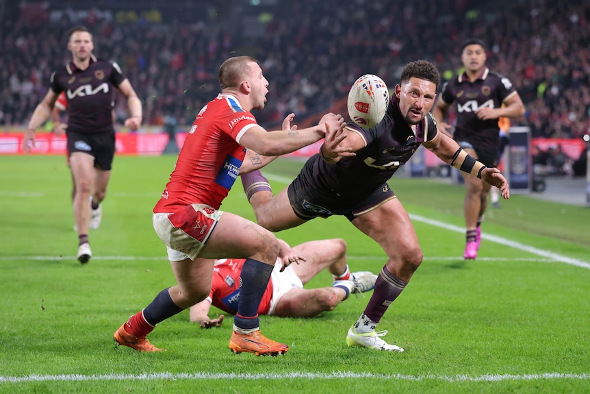 Mikey Lewis of Hull KR and Gehamat Shibasaki of the Brisbane Broncos challenge for the ball.