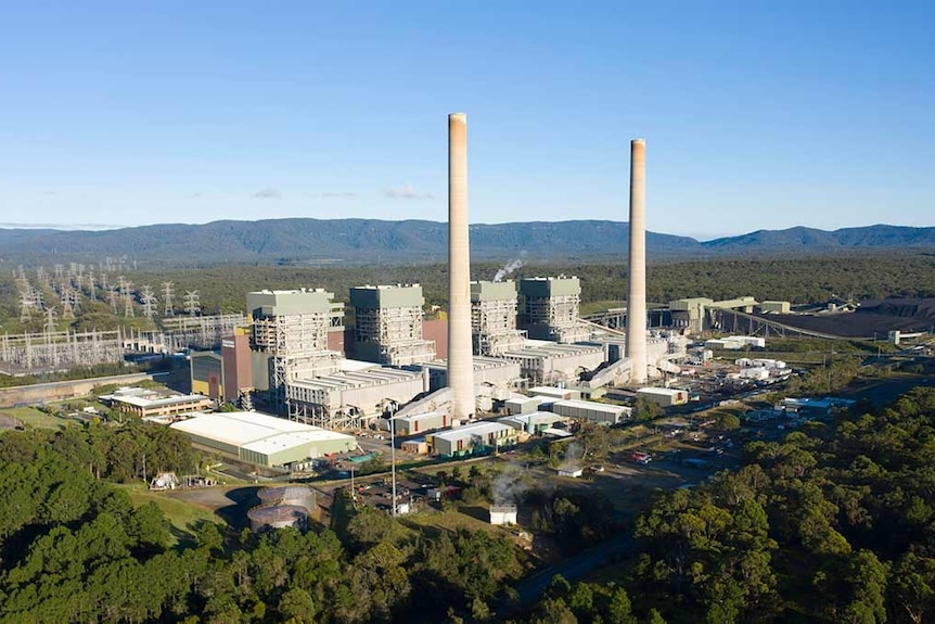 An aerial view of a large power station with two tall smoke stacks.