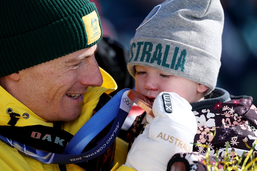 Dual bronze medallist Matt Graham shows daughter Ada his WInter Olympics bronze medal.