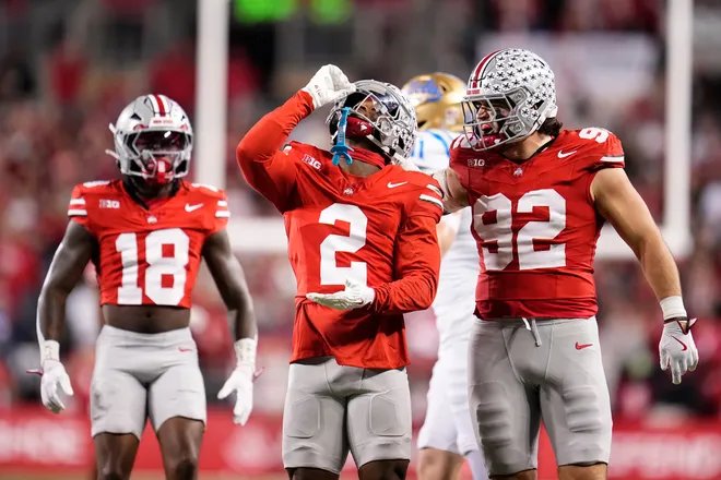 Ohio State Buckeyes defensive back Caleb Downs (2) celebrates a tackle with defensive end Caden Curry (92) and safety Jaylen McClain (18) during the NCAA football game against the UCLA Bruins at Ohio Stadium in Columbus on Nov. 15, 2025.