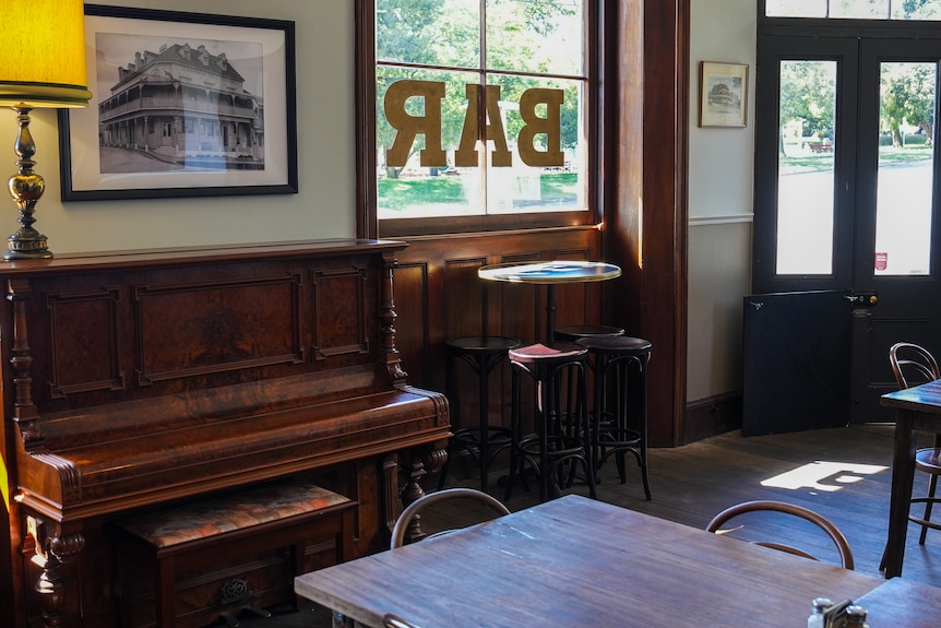Inside of a pub, showing seats and a piano.