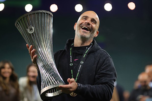Enzo Maresca, the manager of Chelsea, lifts the UEFA Conference League trophy.
