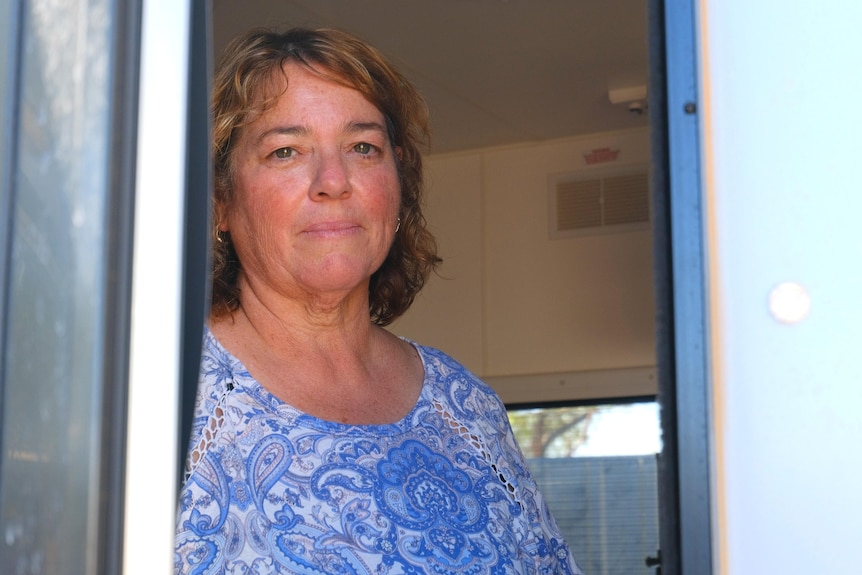 Melinda Byrne standing in the doorway of her caravan looking at the camera.