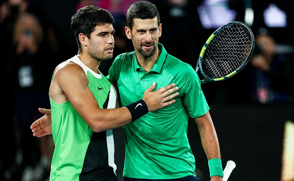 Novak Djokovic, pictured here breaking with tradition and meeting Carlos Alcaraz on his side of the court.