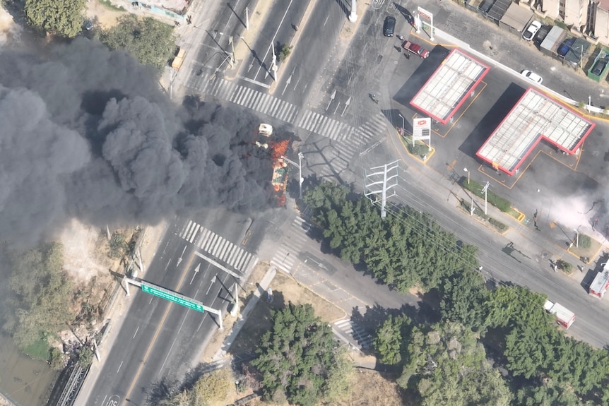 A drone view shows smoke rising from a burning vehicle after the raid.