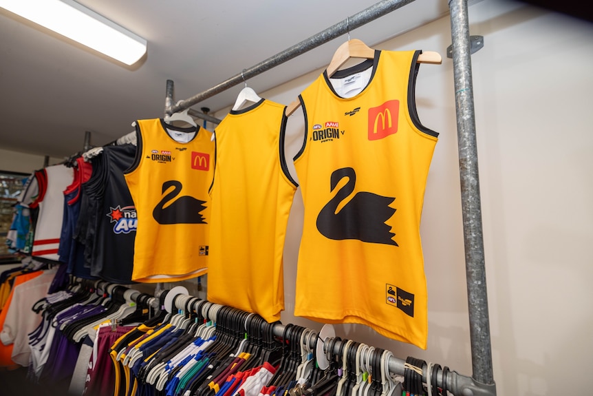 Yellow football jumpers with a black swan in the middle. 