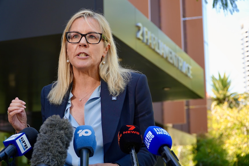Libby Mettam wears a blue blazer and top while holding a press conference