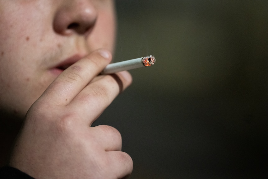 Close up shot of a man smoking a cigarette. 
