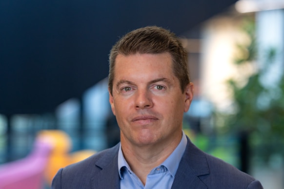 A dark-haired man in a dark suit.