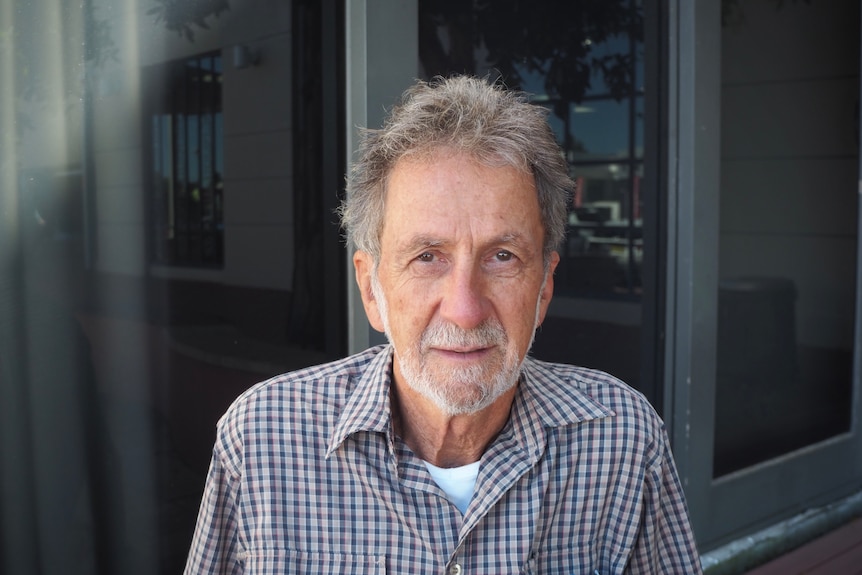 A man with a beard and a checkered shirt.