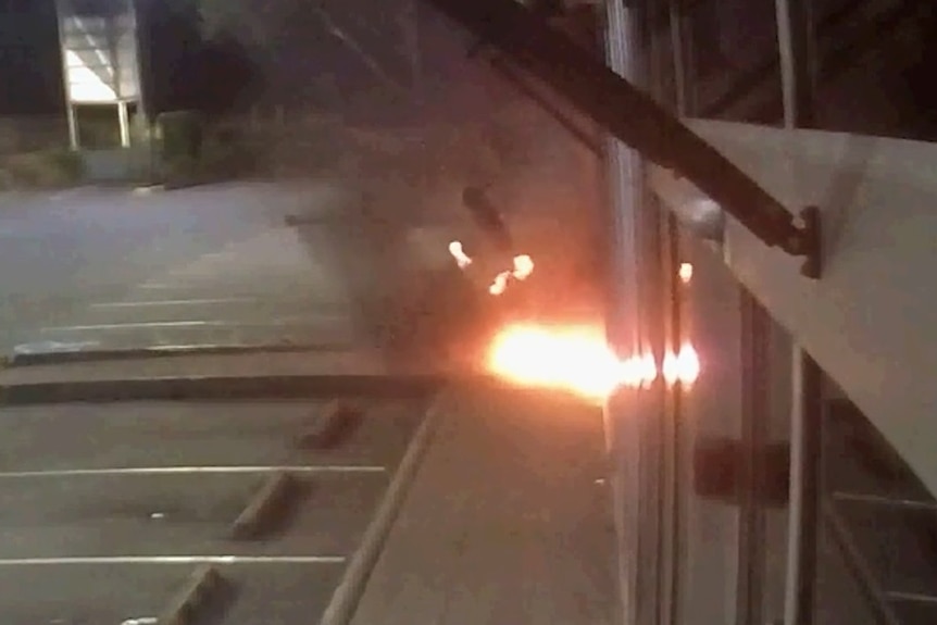 CCTV screenshot shows a man on fire as a shopfront explodes in flames.