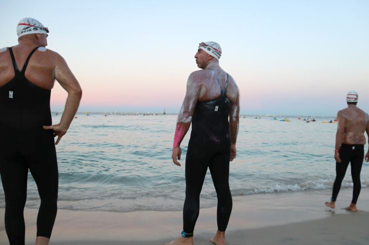 David Hewitt stands on Cottesloe beach with two mates, preparing to swim to Rottnest.