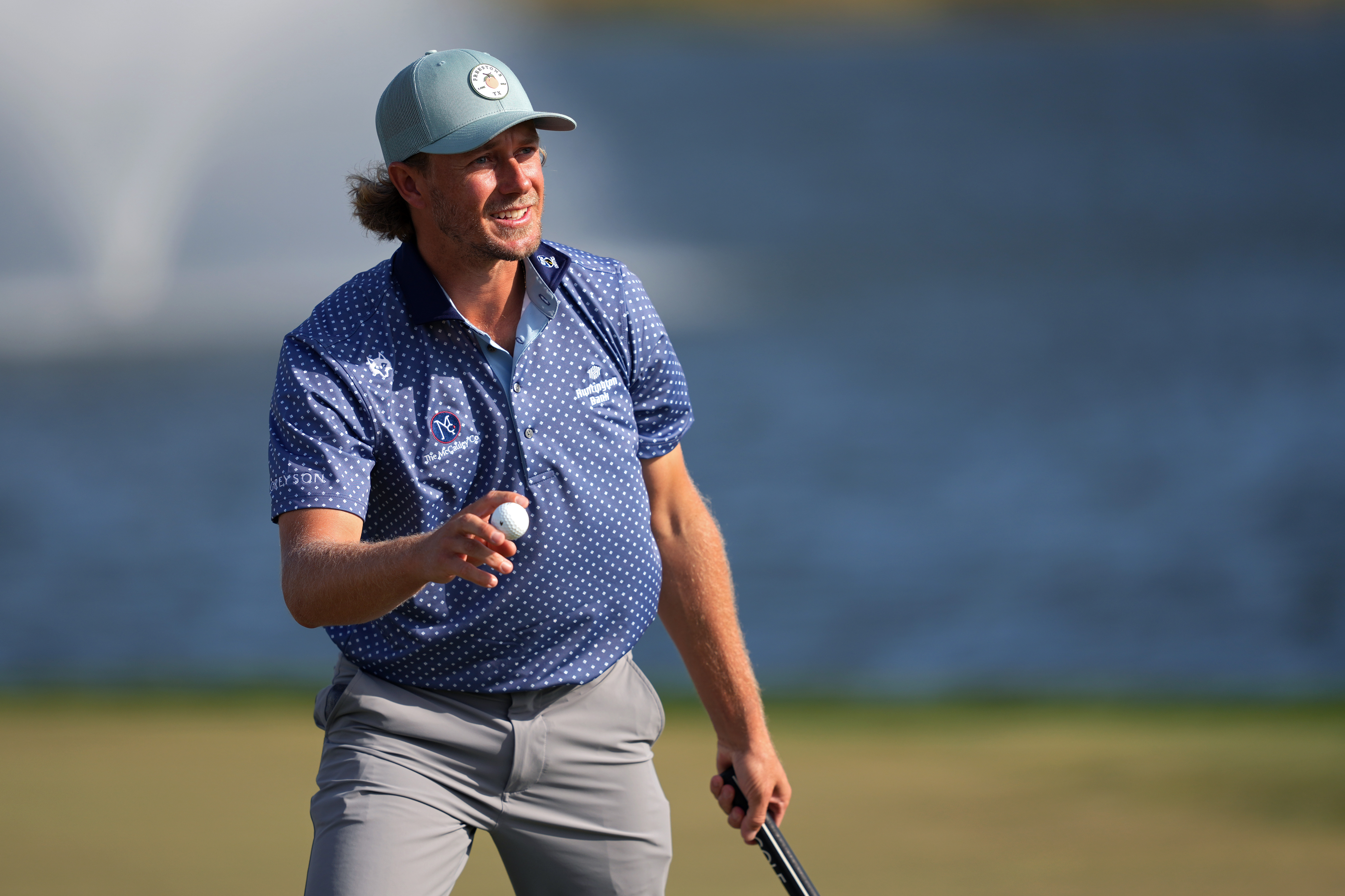 Austin Smotherman waves to the crowd after holing a putt