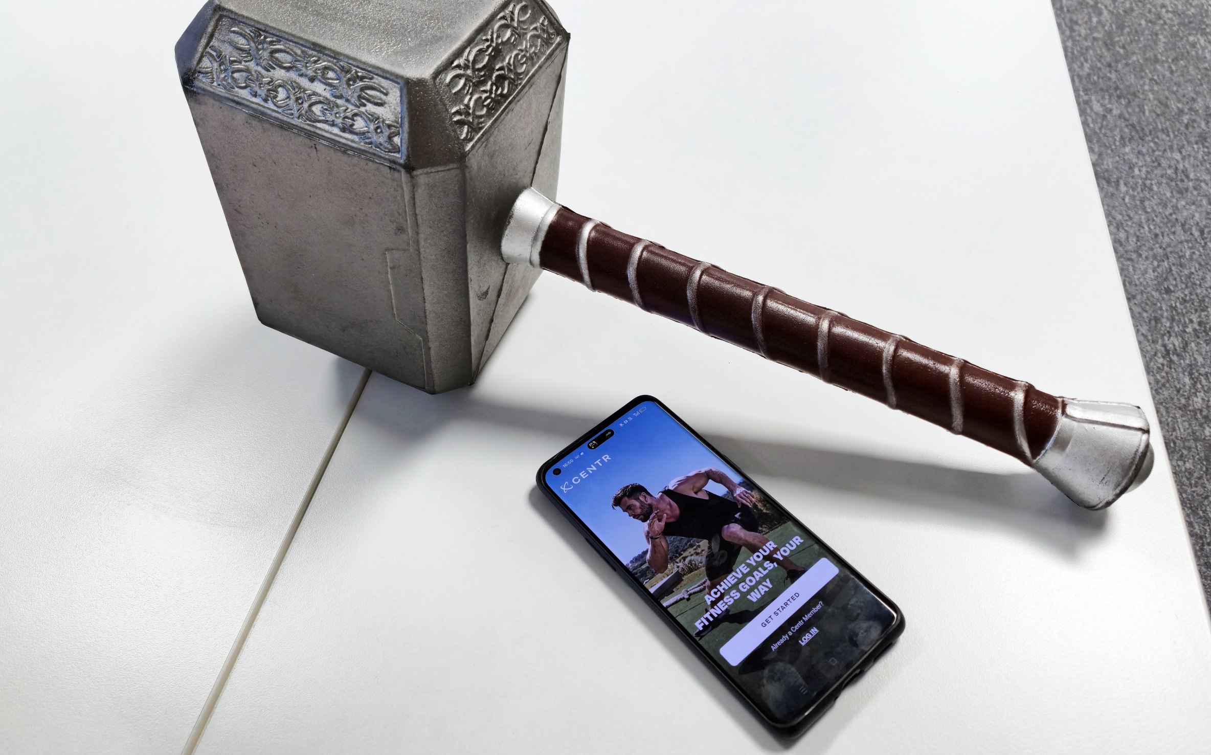Mjolnir toy near phone with Centr app