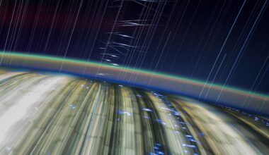 streaks of light crisscross a dark blue sky above a blurry earth below