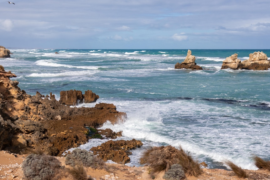 white waves crashing into rocky cliffs