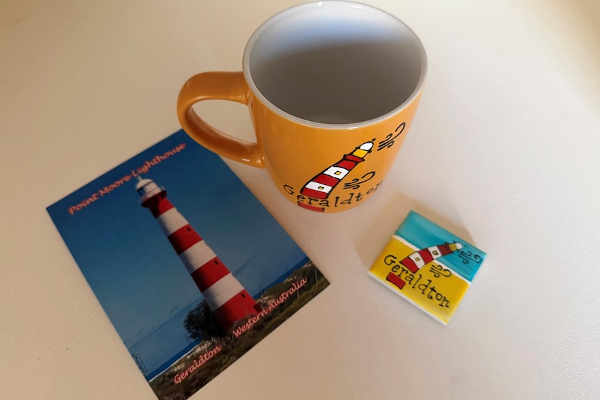 Close-up of lighthouse mug, post-card and fridge magnet.