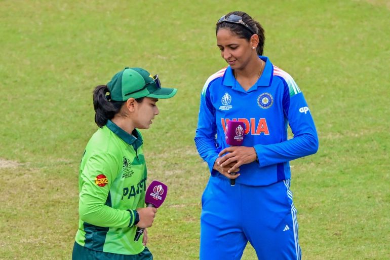 India's captain Harmanpreet Kaur and her Pakistani counterpart Fatima Sana walk past after the toss ahead of the ICC Women's Cricket World Cup 2025 one-day international (ODI) match between India and Pakistan at the R. Premadasa International Cricket Stadium in Colombo on October 5, 2025. (Photo by Ishara S. KODIKARA / AFP)