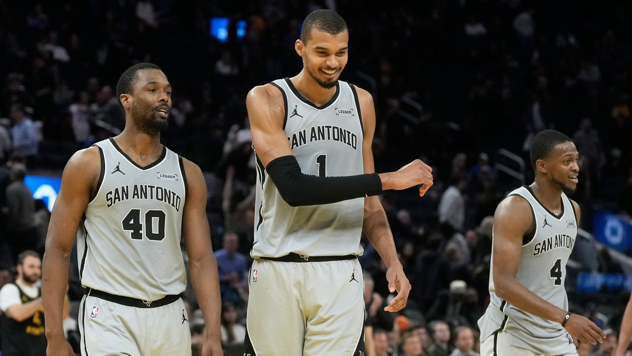San Antonio Spurs forward Harrison Barnes (40) celebrates with center Victor Wembanyama (1) and guard De'aaron Fox (4) during the second half of an NBA basketball game against the Golden State Warriors in San Francisco, Wednesday, Feb. 11, 2026. (AP Photo/Jeff Chiu)