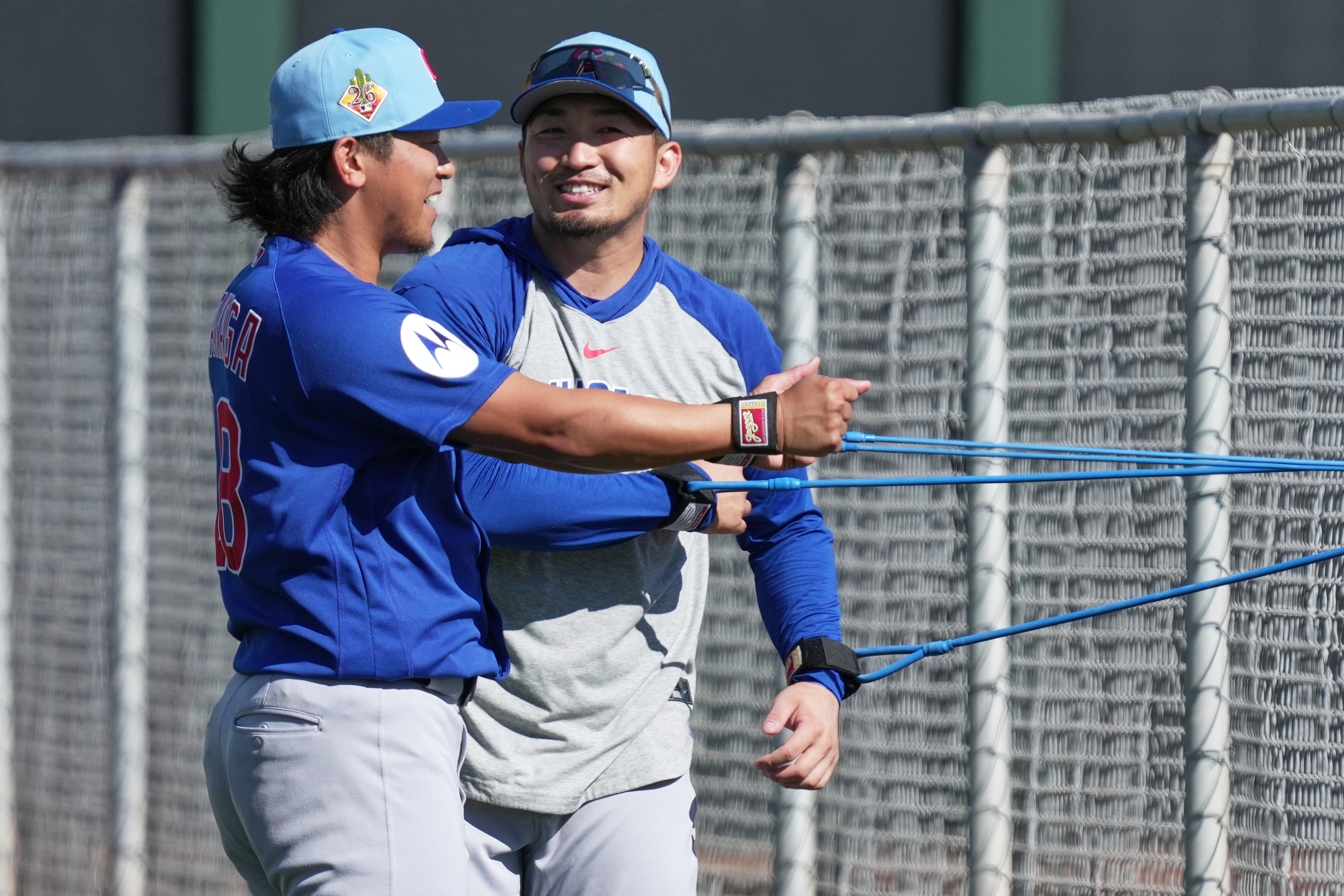 Cubs right fielder Seiya Suzuki and starter Shota Imanaga stretch...