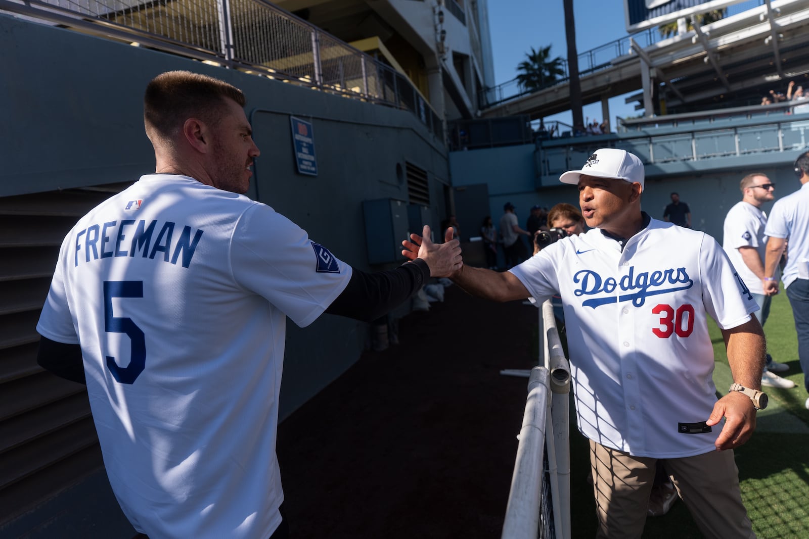 Los Angeles Dodgers manager Dave Roberts, right, and first baseman Freddie Freeman shake hands during DodgerFest at Dodger Stadium in Los Angeles, Saturday, Jan. 31, 2026. (AP Photo/Jae C. Hong)