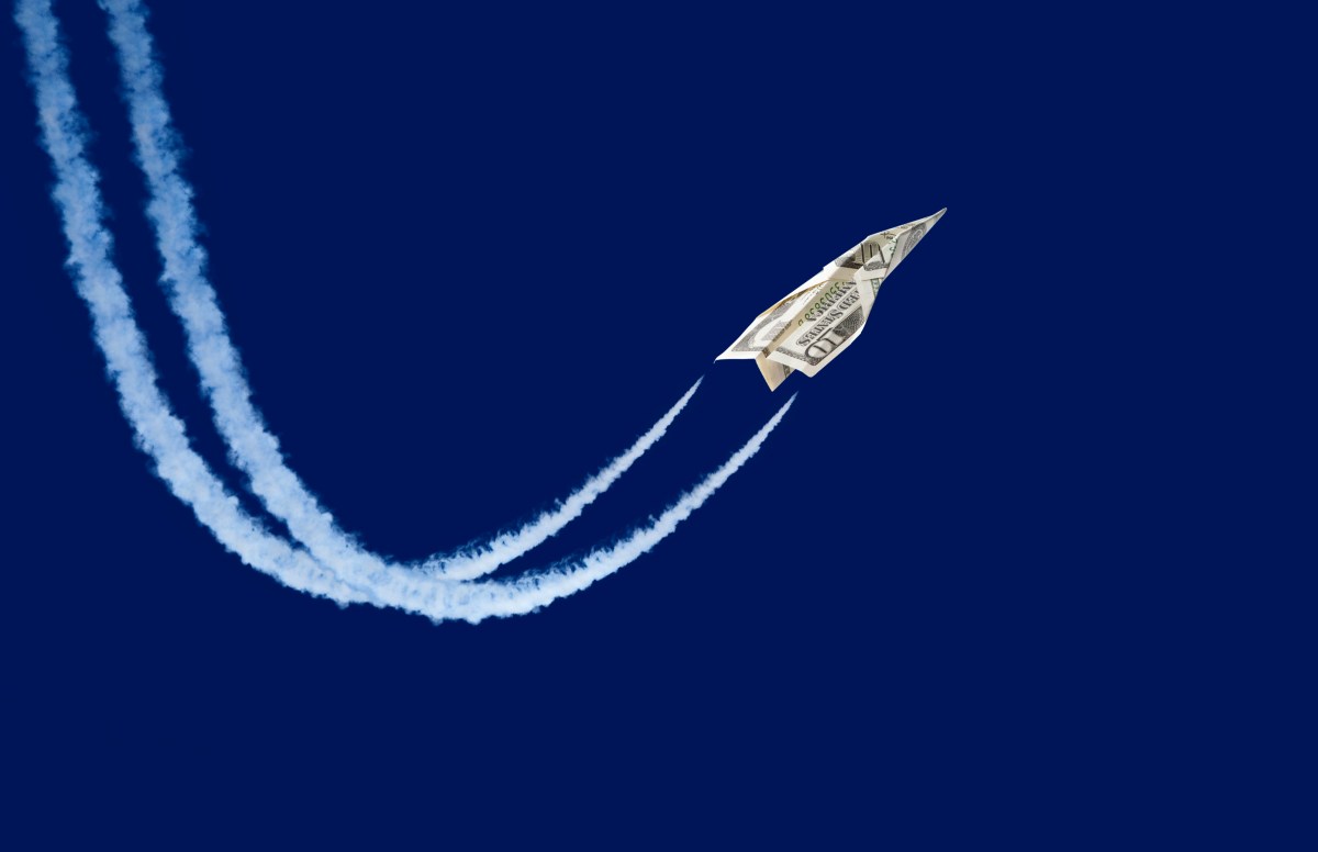 paper plane made from a ten-dollar bill 'flying' with contrails