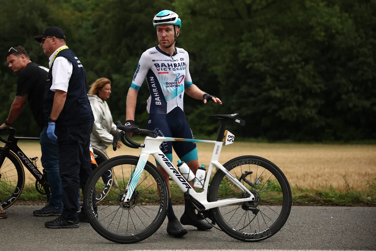 Bahrain - Victorious team's British rider Fred Wright, seen with a visible head injury, recovers after suffering a crash at the back of the pack of riders (peloton) during the 2nd stage of the 112th edition of the Tour de France cycling race, 209.1 km between Lauwin-Planque and Boulogne-sur-Mer, Northern France, on July 6, 2025. (Photo by Anne-Christine POUJOULAT / AFP) (Photo by ANNE-CHRISTINE POUJOULAT/AFP via Getty Images)