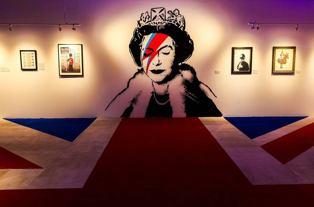 A mural of the queen of England at The Art of Banksy exhibit in San Diego