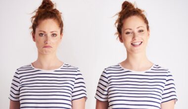 Young women twins standing next to each other. One is smiling and the other is grumpy