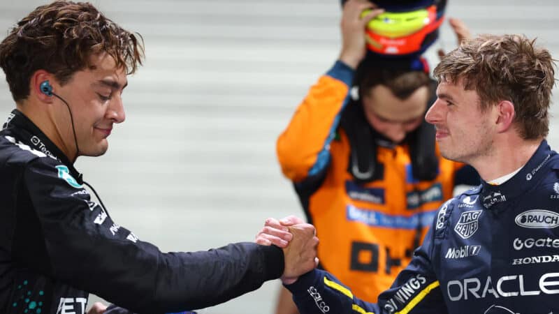 Max Verstappen smirks as he shakes hands with George Russell after the 2025 F1 Singapore Grand Prix