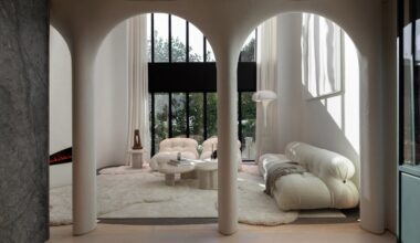 An image showing a contemporary, white living room that can be seen through curved archways.