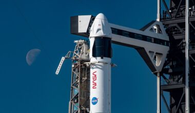 a white and black rocket with NASA markings on it stands poised on a launch pad awaiting its day to launch